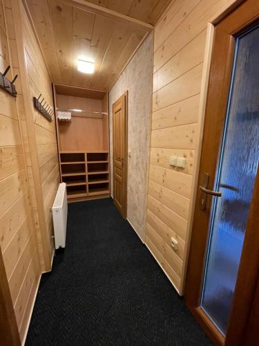 a walk in closet with wooden walls and a door at Chata Sedloňov in Sedloňov