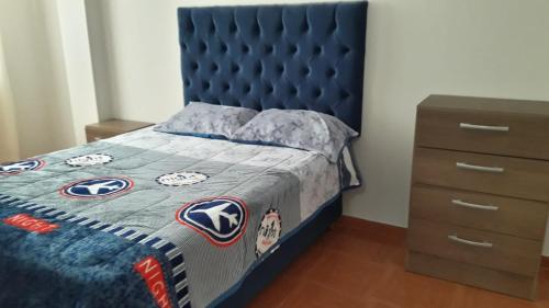 1 dormitorio con cama azul y cabecero azul en Hermoso departamento en chorrillos, en Lima