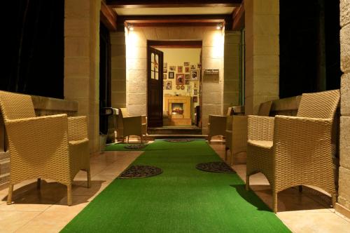 a green carpet in a hallway with chairs at Willa Barbara - ProHarmonia in Lądek-Zdrój