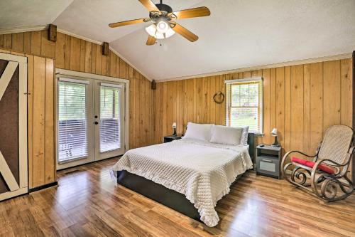 a bedroom with a bed and a ceiling fan at 1950s Serenity Pond Cabin with View Peace and Quiet! in Talladega