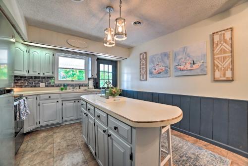 a kitchen with blue and white cabinets and a island at Lakefront Moors Marina Condo with Covered Boat Slip! in Gilbertsville