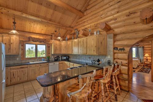 a kitchen with wooden cabinets and a counter in a cabin at Exquisite Log Home with Lander Valley Views! in Lander