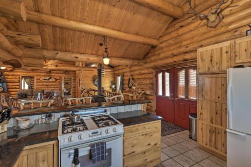 a kitchen with a stove and a refrigerator at Exquisite Log Home with Lander Valley Views! in Lander