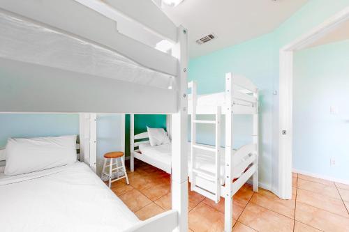 a dorm room with two bunk beds and a table at Sandpiper Villa in Galveston