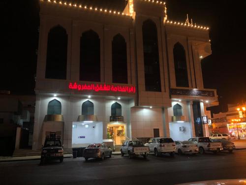a building with cars parked in front of it at night at زائر الفخامه للشقق المخدومه in Tabuk
