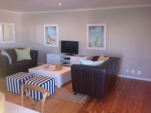 a living room with two couches and a tv at Kenjockity Self Catering Apartments in Hermanus