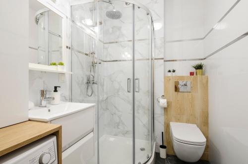 y baño con ducha, aseo y lavamanos. en ApartHouse Deluxe en Lodz