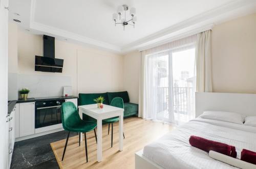 1 dormitorio con 1 cama, mesa y sillas en ApartHouse Deluxe en Lodz