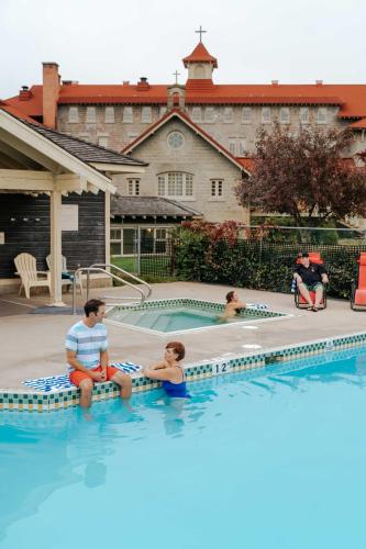 a man and two children sitting on mats in a swimming pool at St. Eugene Golf Resort & Casino in Cranbrook