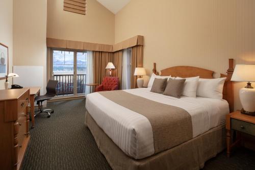 a hotel room with a large bed and a desk at St. Eugene Golf Resort & Casino in Cranbrook