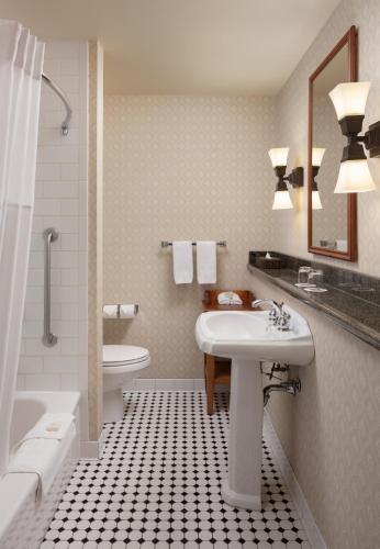 a bathroom with a sink and a tub and a toilet at St. Eugene Golf Resort & Casino in Cranbrook