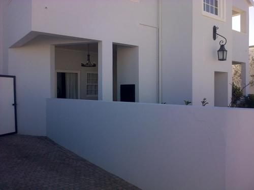 a white wall with a mirror on the side of a building at Kenjockity Self Catering Apartments in Hermanus