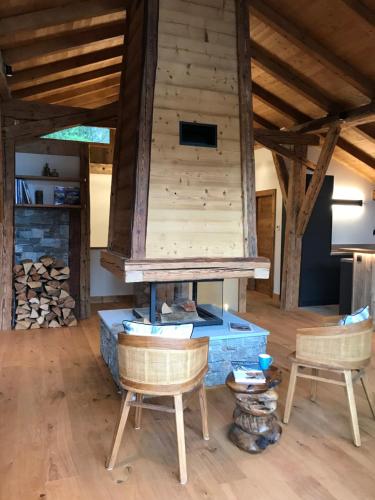 sala de estar con chimenea y 2 sillas en Chalet Grand Standing Vallée Chamonix Mont Blanc en Servoz