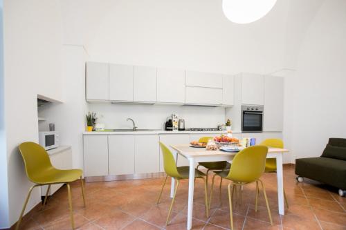 een witte keuken met een tafel en stoelen bij Giulia's House in Galatina