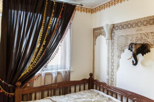 an elephant head on the wall of a bedroom at Hotel General in Ekibastuz