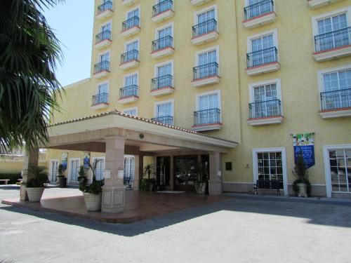 a large yellow building with a entrance to it at Best Western Hotel Posada Del Rio Express in Torreón