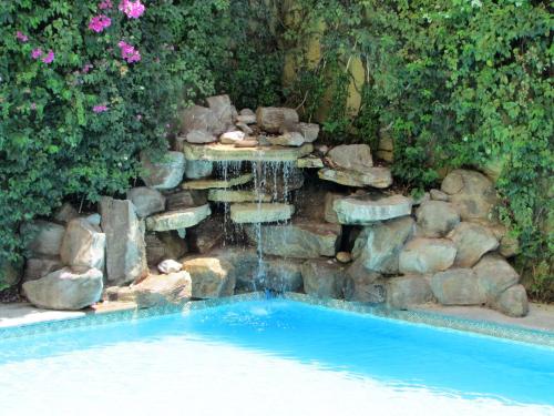 a waterfall in a yard with a swimming pool at Best Western Hotel Posada Del Rio Express in Torreón