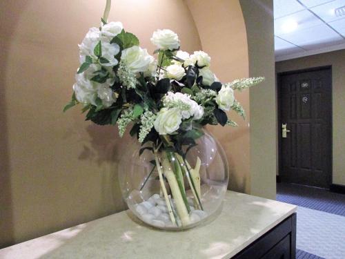 a vase filled with white flowers on a table at Best Western Hotel Posada Del Rio Express in Torreón