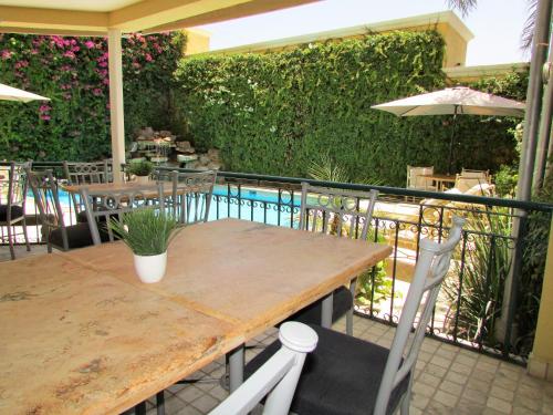 a table and chairs on a patio with a hedge at Best Western Hotel Posada Del Rio Express in Torreón