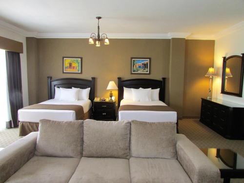 a living room with two beds and a couch at Best Western Hotel Posada Del Rio Express in Torreón