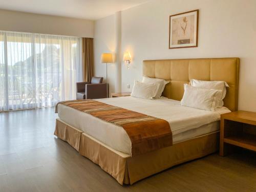 a bedroom with a large bed in a hotel room at Foz Club - Algarve in Alvor