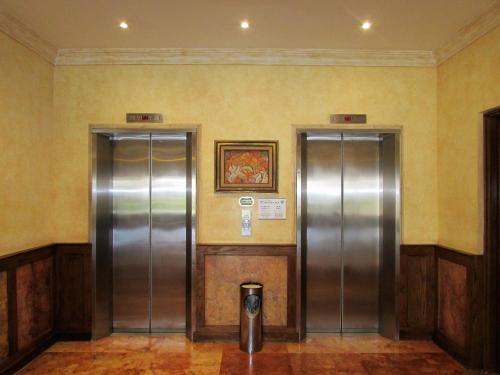 two metal elevators in a room with a picture on the wall at Best Western Hotel Posada Del Rio Express in Torreón