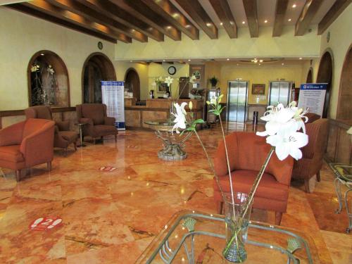 a lobby with chairs and a vase of flowers at Best Western Hotel Posada Del Rio Express in Torreón