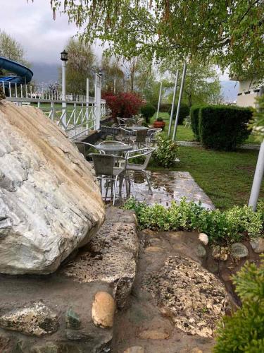 a garden with a table and a large rock at Hotel Royal in Tetovo