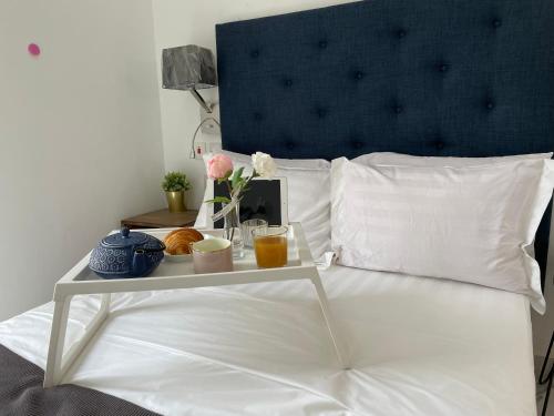 a bed with a table with a tray of food on it at Mica Apartments in Sere Kunda