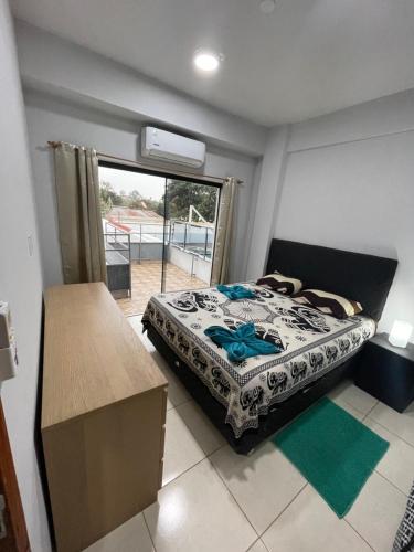 a bedroom with a bed in a room with a window at WilMar Apart Hotel in Encarnación