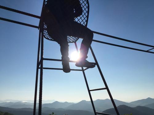 a person on a ladder with the sun in the background at Santari in Shintoku