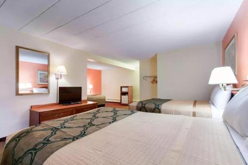a hotel room with two beds and a flat screen tv at Royal Inn Clearfield in Clearfield