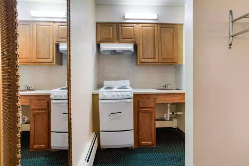 a small kitchen with wooden cabinets and a stove at Royal Inn Clearfield in Clearfield