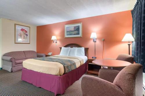 a hotel room with a bed and two chairs at Royal Inn Clearfield in Clearfield
