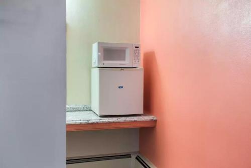 a microwave on top of a refrigerator on a shelf at Royal Inn Clearfield in Clearfield
