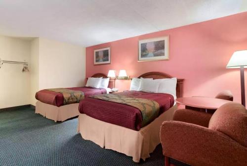 a hotel room with two beds and a chair at Royal Inn Clearfield in Clearfield