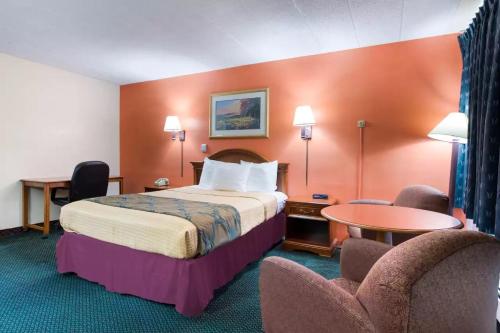 a hotel room with a bed and two chairs at Royal Inn Clearfield in Clearfield