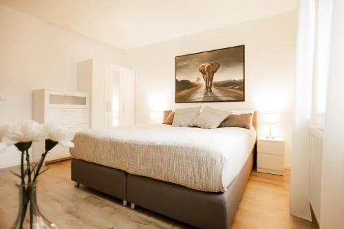 1 dormitorio con 1 cama con una pintura en la pared en bonquartier - groß & stylisch - zentral & komfortabel, en Siegburg