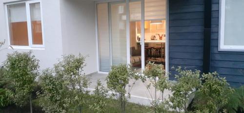 a house with a glass door with a dining room at Exceptional Deluxe Apartment Pucon near Lake and Volcano in Pucón