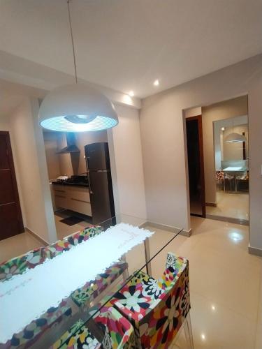 a living room with a table and chairs and a light at Premium Flat Praia Calma - PontaNegra in Natal