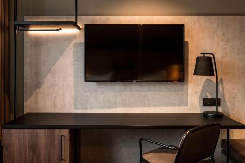 a desk with a television and a lamp at Radisson Blu Polar Hotel, Spitsbergen in Longyearbyen