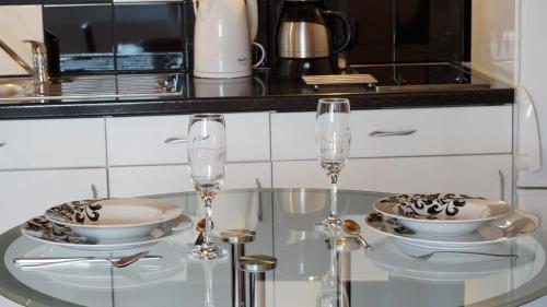扎达尔A&N Zadar的一张玻璃桌,上面有两个盘子和玻璃杯