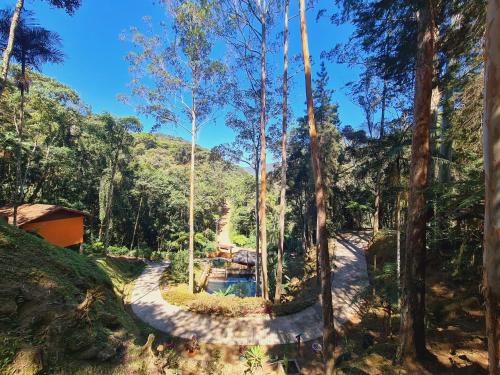 a resort with a pool in the middle of a forest at Recanto dos Sonhos Guest House in Lumiar