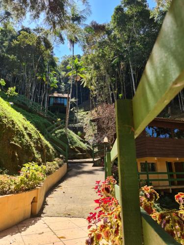 a walkway in a garden with flowers and trees at Recanto dos Sonhos Guest House in Lumiar