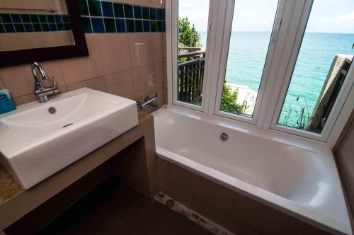 a bathroom with a sink and a tub and a window at Penn Sunset Villa 7 in Ko Lanta