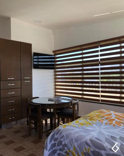 a bedroom with a table and a bed and a table and chairs at Departamentos Bonsai in Torreón