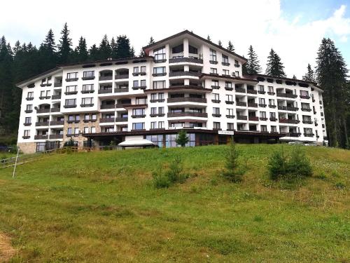 ein großes Gebäude auf einem Grashügel in der Unterkunft Deer's Home at Elit Pamporovo in Pamporowo