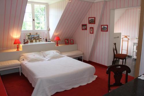 ein Schlafzimmer mit einem weißen Bett und einem Fenster in der Unterkunft Résidence Clairbois, Chambres d'Hôtes in Fère-en-Tardenois