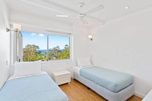 A bed or beds in a room at Noosa Escape 2Br Allambi Rise