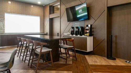 a bar with stools and a tv on a wall at Holiday Inn Express & Suites - Tijuana Otay by IHG in Tijuana